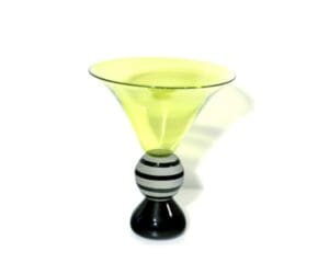 A yellow glass bowl with black and white striped base.
