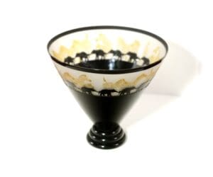 A black and white glass bowl with gold designs.