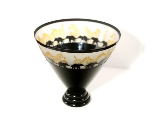 A black and white glass bowl with gold designs.