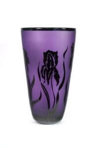 A purple vase with black flowers on it.
