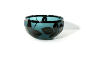 A bowl with leaves on it sitting on top of a table.