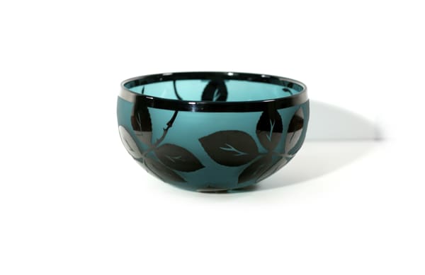 A bowl with leaves on it sitting on top of a table.