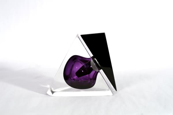 A purple apple sitting on top of a white table.