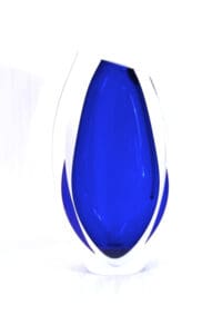 A blue glass vase with white base.