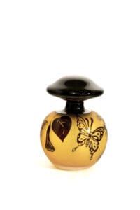 A small glass bottle with a black lid and a butterfly design.