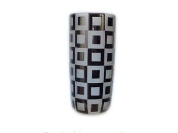 A black and white vase with squares on it