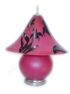 A pink lamp with black leaves on it