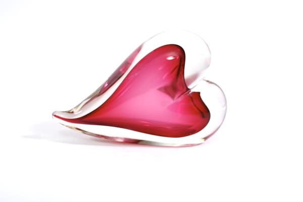 A red heart shaped object sitting on top of a table.