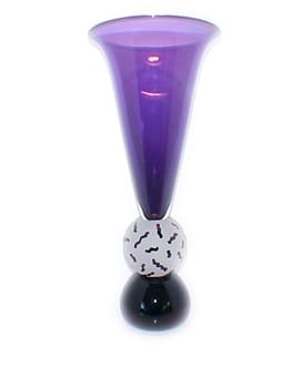 A purple vase with black and white balls on top of it.