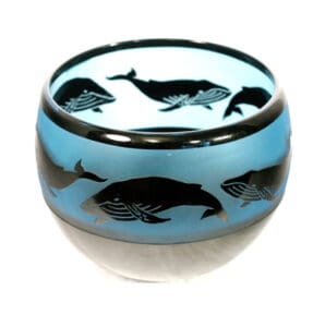A blue bowl with black whale designs on it.
