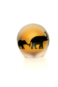 A glass egg with an elephant and baby on it.