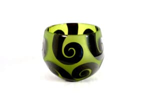 A green and black glass bowl with swirls