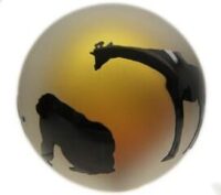 A giraffe and two monkeys are silhouetted against the sun.