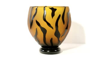 A glass vase with a tiger stripe pattern.