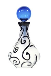 A white and black swirl glass bottle with blue top.