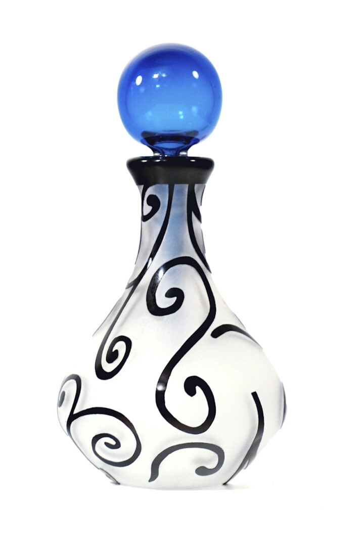 A white and black swirl glass bottle with blue top.