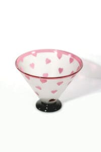 A glass bowl with pink hearts on it.
