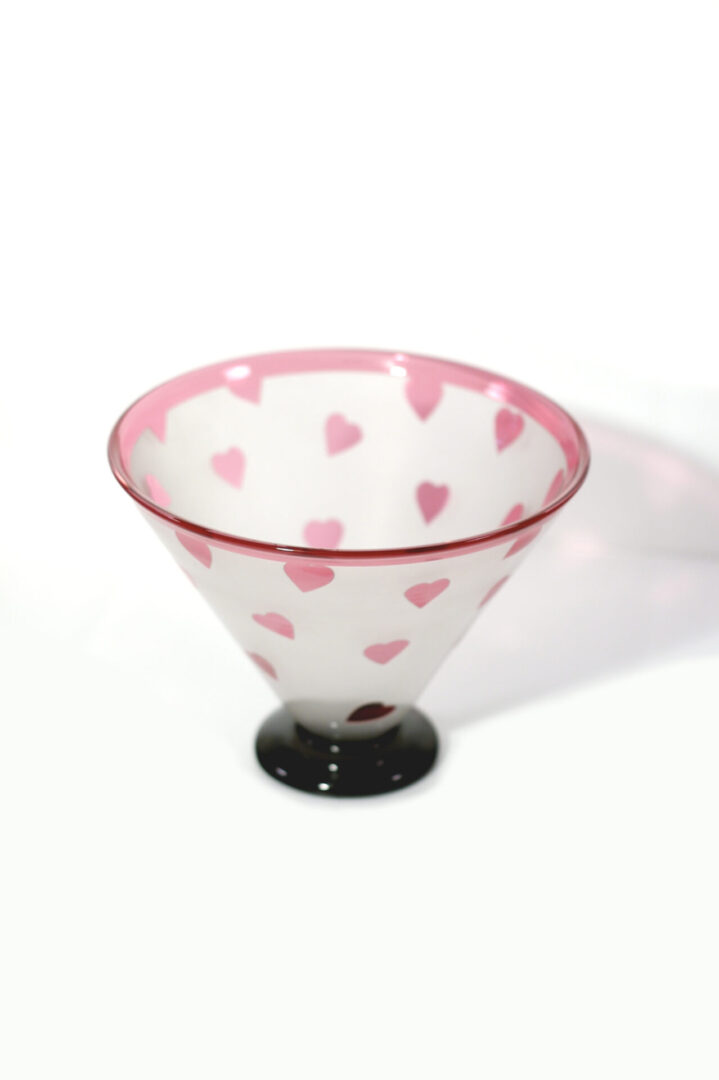 A glass bowl with pink hearts on it.