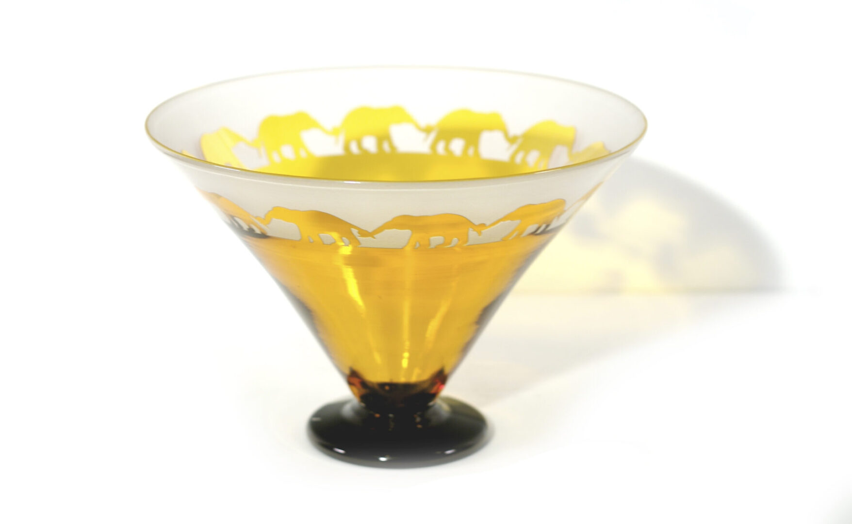 A glass bowl with yellow elephants on it.