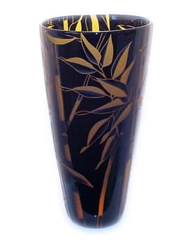 A black vase with gold leaves on it