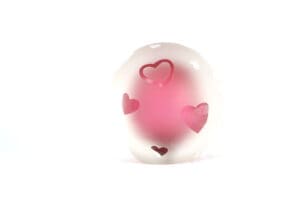 A pink heart shaped object sitting on top of a table.