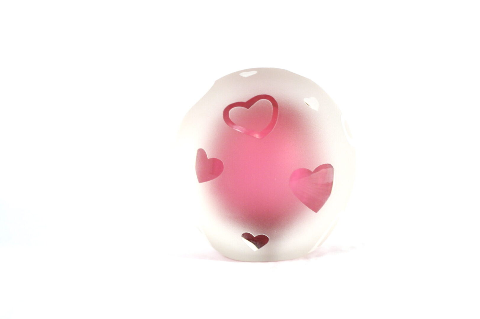 A pink heart shaped object sitting on top of a table.