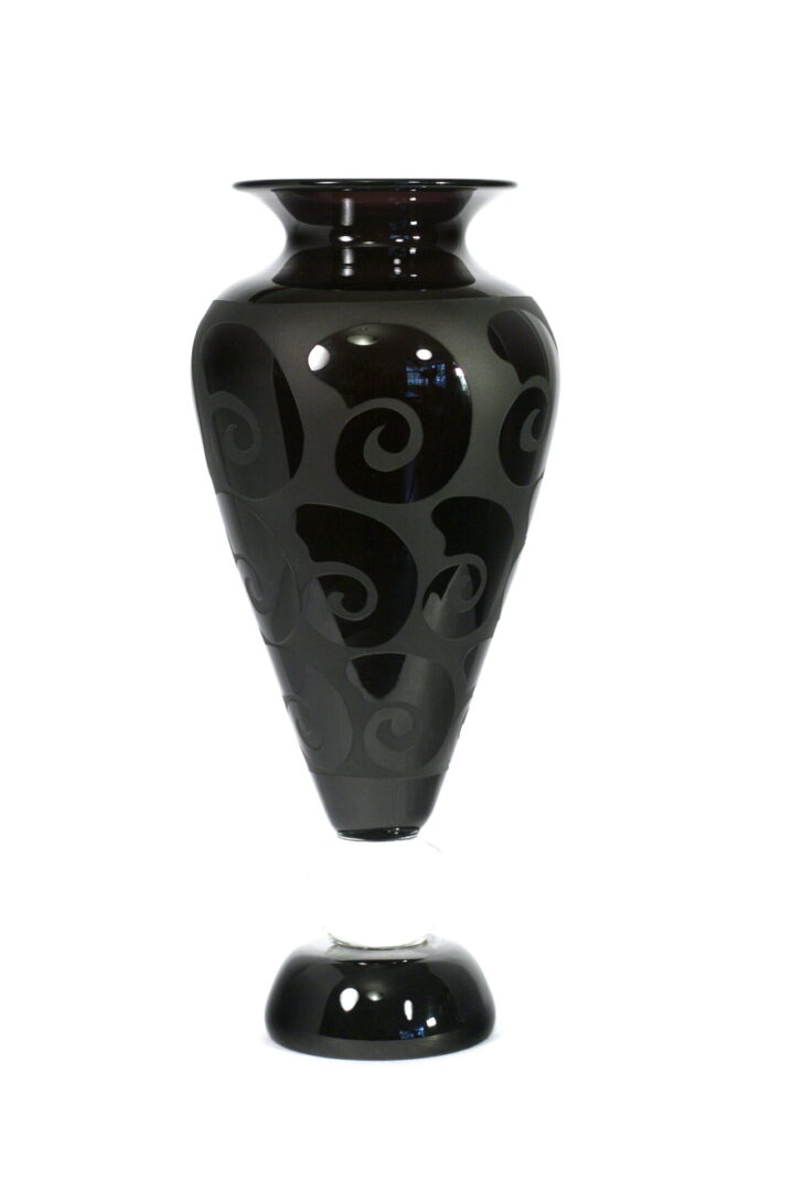 A black vase with swirls on it