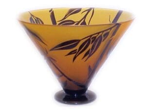 A glass bowl with brown leaves on it.