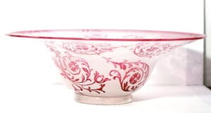 A bowl with red and white design on it.