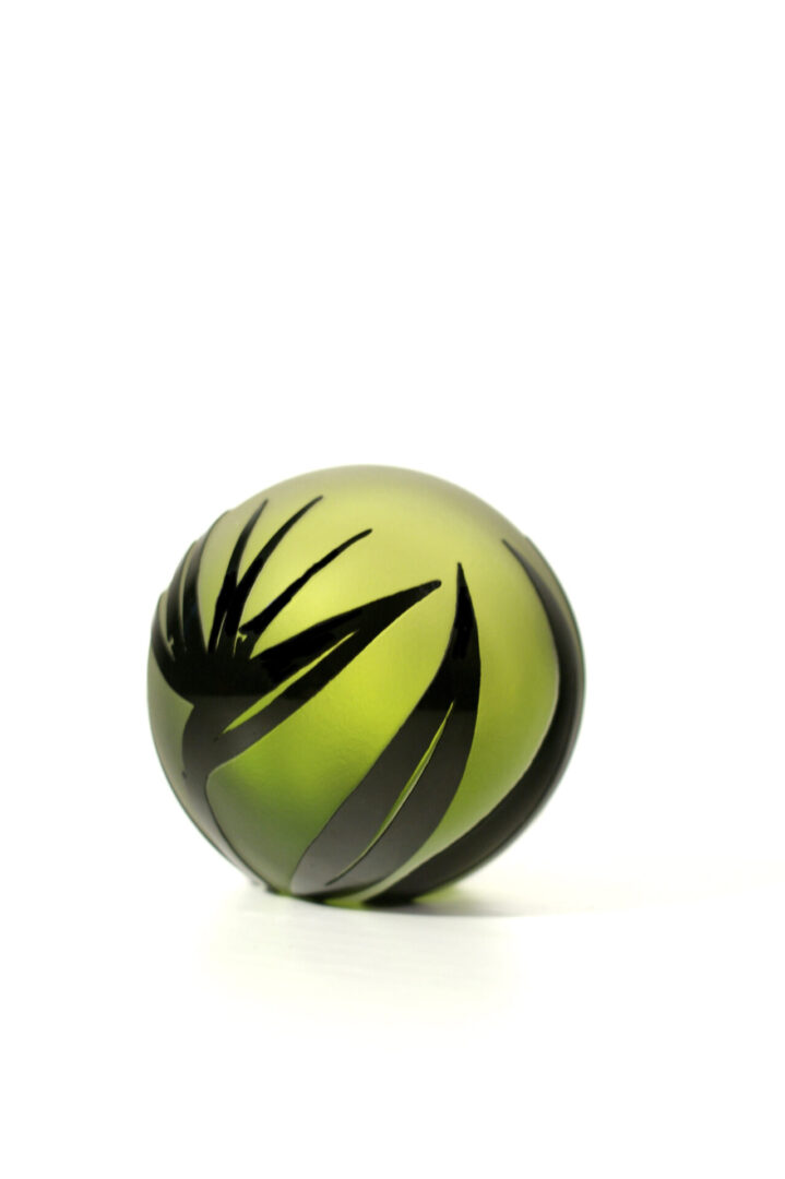 A green ball with black designs on it.