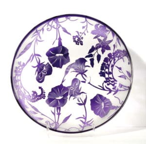 A purple and white plate with flowers on it