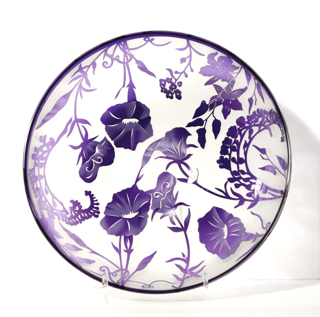 A purple and white plate with flowers on it
