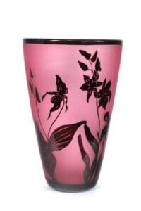 A pink vase with black flowers on it