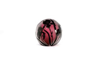 A pink and black ball with flowers on it.