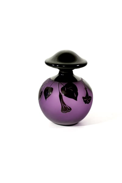 A purple glass vase with black design on it.