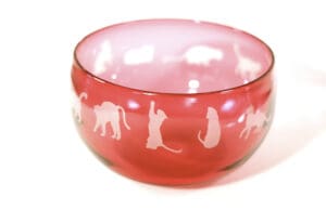 A bowl with cats on it is sitting in the middle of the picture.