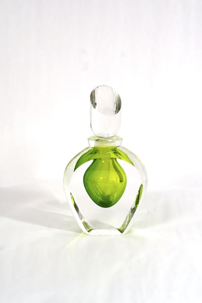 A green glass bottle with a lime on it.
