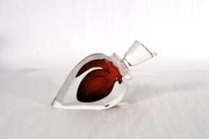 A glass bottle with red liquid inside of it.