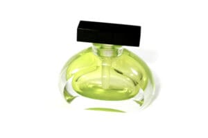 A green bottle of perfume sitting on top of a table.