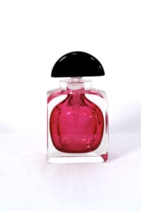 A bottle of pink perfume on top of a table.