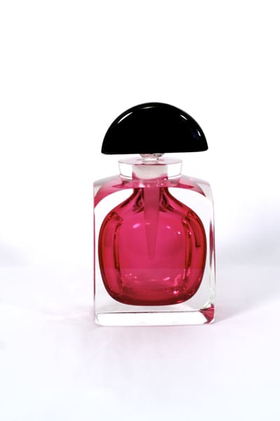 A bottle of pink perfume on top of a table.