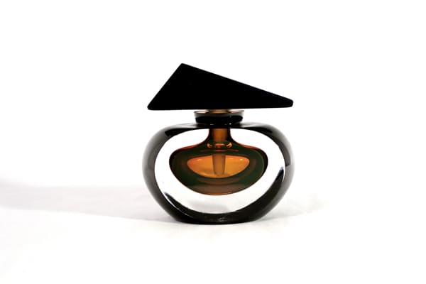 A black and brown bottle of perfume on top of a table.