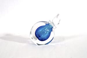 A blue glass bottle sitting on top of a white table.