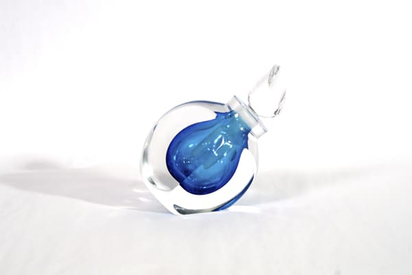 A blue glass bottle sitting on top of a white table.