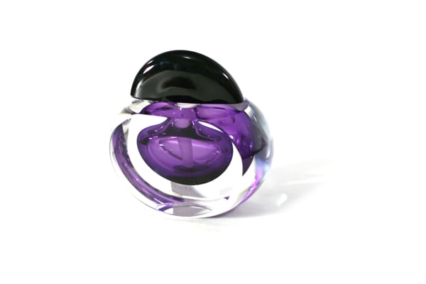 A purple and black glass object on top of a white surface.
