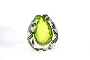 A green glass object with black and white designs.