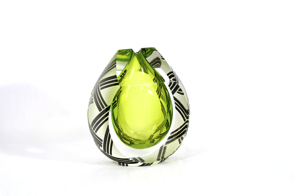 A green glass object with black and white designs.