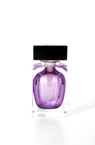A purple bottle of perfume sitting on top of a table.