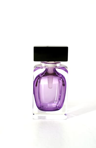 A purple bottle of perfume sitting on top of a table.