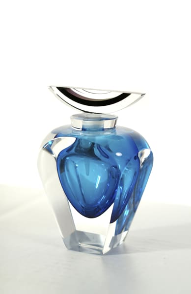 A blue glass vase with a clear lid.